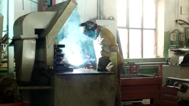 Práce svářeč v továrně v ochranný oblek svary část, svářečka je část, výroba, svařování — Stock video