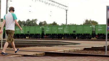 Genç bir adam Kulaklığımda demiryolu parça geçerek ve müzik dinliyor, yaklaşan tren duymuyor