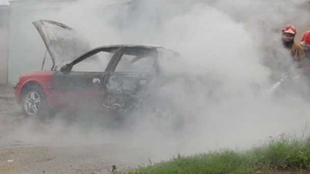 BOBRUISK, BELARUS - JULY 25, 2018: firefighters or firemen extinguish a burning automobile after self-ignition — Stock Video