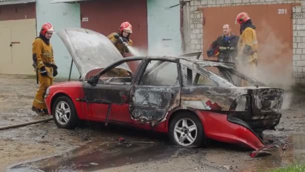 BOBRUISK, BELARUS - JULY 25, 2018: firefighters or firemen extinguish burnt car after act of terrorism — Stock Video