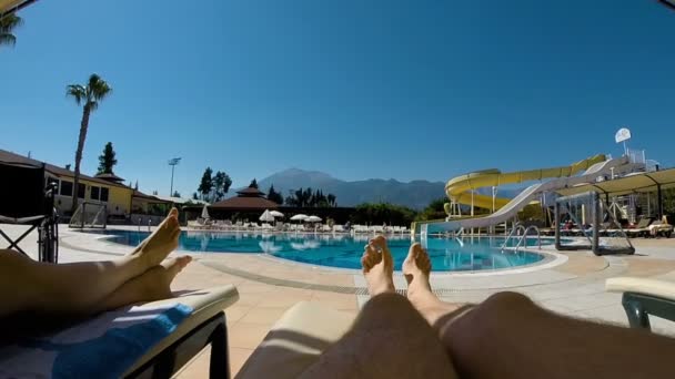 Benen ligga på en solstol vid poolen — Stockvideo