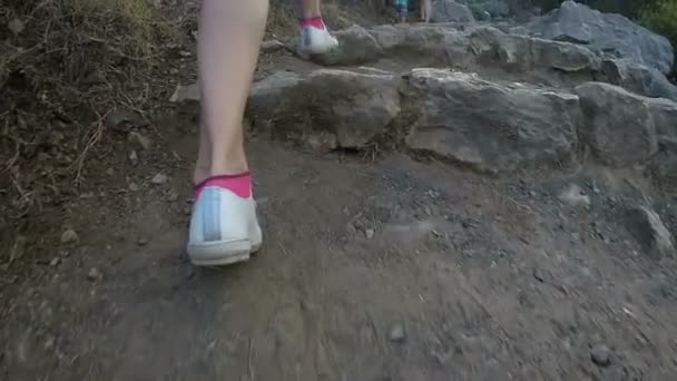 Frauenfüße in Turnschuhen erklimmen die uralte Steintreppe — Stockvideo