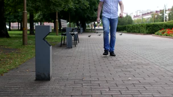 Młody człowiek rzuca plastikową butelkę w mieście w pobliżu kosz na śmieci — Wideo stockowe
