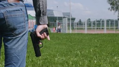 adam elinde bir tabanca ile parkta, çocukların risk altında olduğunu.