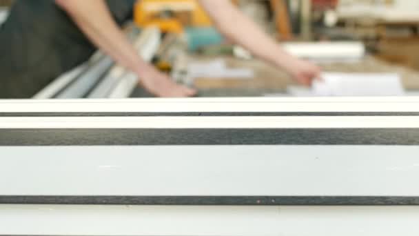 Manufacture of PVC windows, the male worker checks the dimensions according to the PVC profile documents, for the production of pvc windows, pvc frame — Stock Footage Manufacture Pvc Windows Male Worker Checks Dimensions According Pvc Profile Video Clip