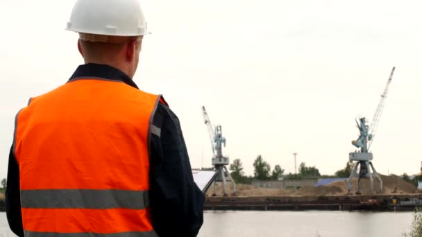 O inspector regista os problemas identificados no funcionamento dos guindastes portuários no porto — Vídeo de Stock