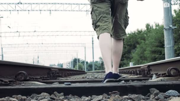 Άνθρωπος με ακουστικά που περπατά κατά μήκος του σιδηροδρόμου, επικίνδυνες για τη ζωή — Αρχείο Βίντεο