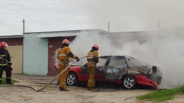 BOBRUISK, BÉLARO - 25 DE JULIO DE 2018: bomberos o bomberos extinguen vehículo de pasajeros en llamas después de un acto de terrorismo — Vídeos de Stock