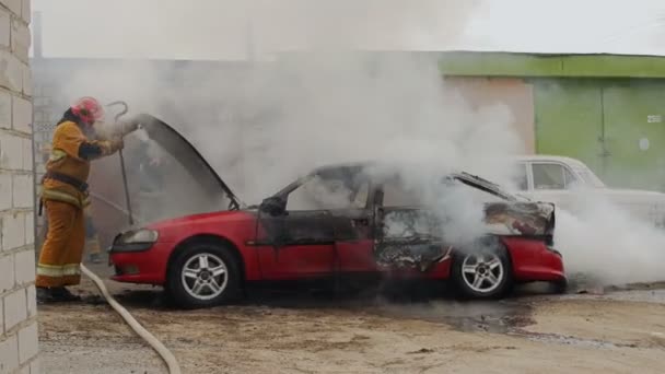 BOBRUISK, BELARUS - JULY 25, 2018: firefighters or firemen extinguish burning passenger car after act of terrorism — Stock Video