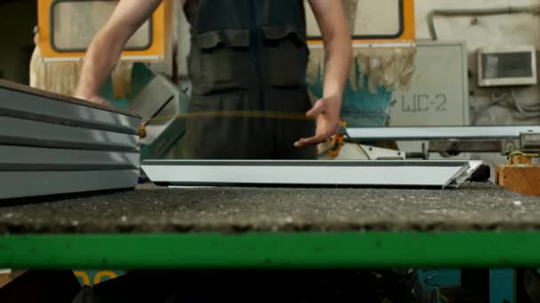 Production et fabrication de fenêtres en pvc, un travailleur masculin mesure une pièce de profil en pvc et le marquage avec un marqueur, ruban à mesurer et marqueur, production — Video