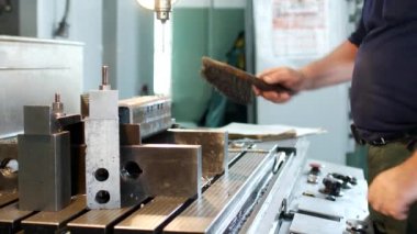 Bir adam konusunda uzmanlaşmış bir delici metal bir parça daha fazla sondaj ve bir sondaj işleme makine, özel bir atölye, el sanatları için hazırlar
