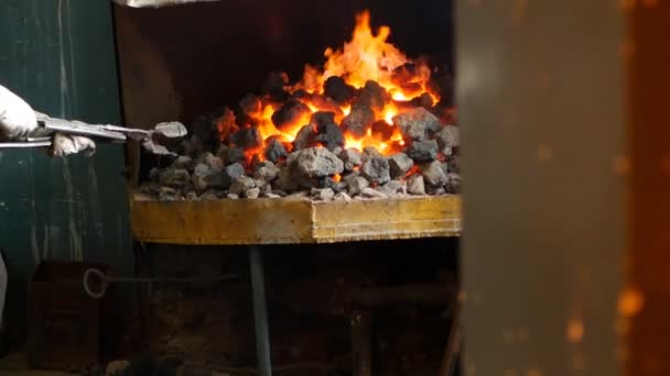 Um ferreiro inverte as peças de metal vermelho-quente no forno, tratamento térmico, endurecimento e aquecimento de metal, forja, câmera lenta — Vídeo de Stock