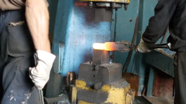 Zwei Schmiede in der Schmiede machen ein Metallteil für den Maschinenbau mit einer Maschine, heißes Metall und Schmiede, Fertigung, slo-mo — Stockvideo