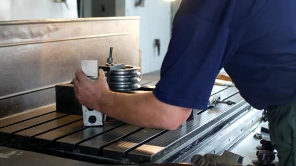 Varón barrenador especialista fija una polea de metal en una máquina de escariado, pequeña empresa, sala de trabajo, ginebra — Vídeo de stock