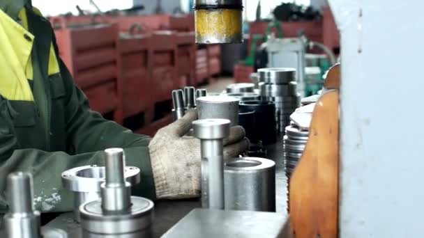 O trabalhador monta a prensagem do rolamento em um clipe de metal na máquina, monta a unidade acabada, close-up, imprensa, ajuste — Vídeo de Stock