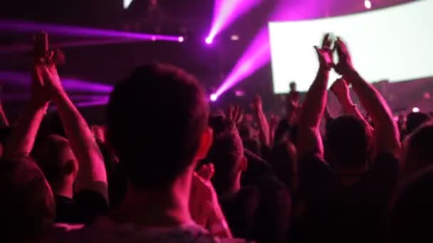 Los fans saludan con las manos al ritmo de la música en el concierto — Vídeo de stock