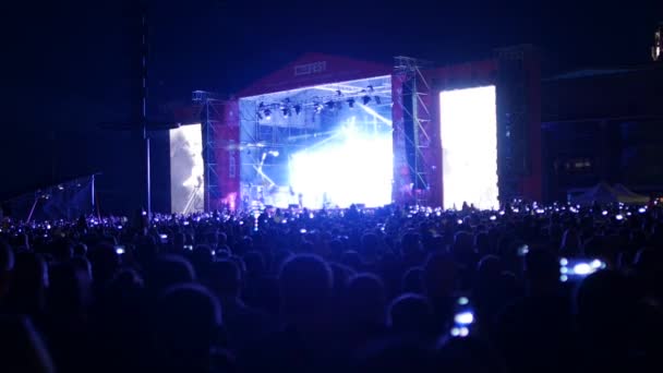 BOBRUISK, BELARUS - 6 DE JULIO DE 2018: una multitud de personas ven en el escenario durante el concierto de la banda Bi-2 en el B2 fest, video tomado con un efecto de velocidad de obturación más baja — Vídeo de stock