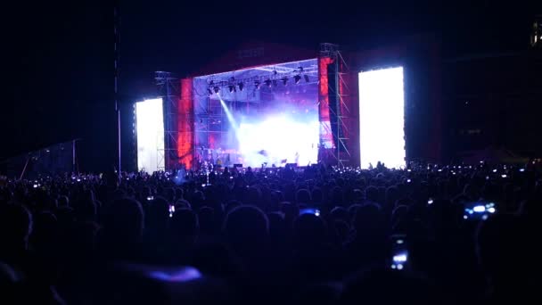 BOBRUISK, BELARUS - 6 DE JULIO DE 2018: una multitud de personas ven en el escenario durante el concierto de la banda Bi-2 en el B2 fest, video tomado con un efecto de velocidad de obturación más baja — Vídeo de stock