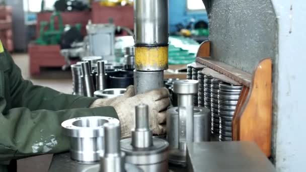 The worker at the plant presses the bearing into the hub using a press machine, assembling the hub, assembling the unit for mechanical engineering, close-up, pillow — Stock Video