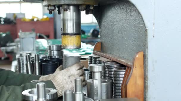 El trabajador de la planta presiona el rodamiento en el cubo utilizando una máquina de prensa, ensamblando el cubo, ensamblando la unidad para ingeniería mecánica, primer plano — Vídeos de Stock