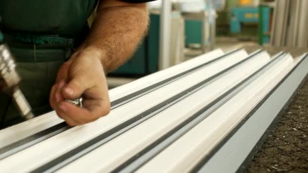 Producción de ventanas de pvc, el trabajador atornilla un perfil de metal al perfil de plástico de la sección de ventanas de pvc, fabricación de ventanas de plástico — Vídeos de Stock
