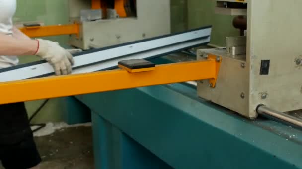 Producción de ventanas de pvc, una trabajadora pone un perfil de pvc en una máquina para soldar las esquinas del perfil de pvc, banco — Vídeo de stock