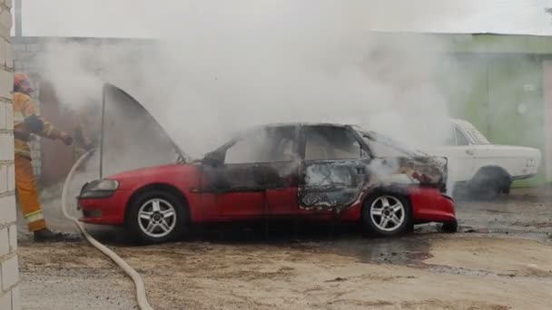 Bobruisk, Wit-Rusland - juli 25, 2018: brandweerlieden of brandweermannen met slang een brandende auto na zelfontbranding blussen — Stockvideo