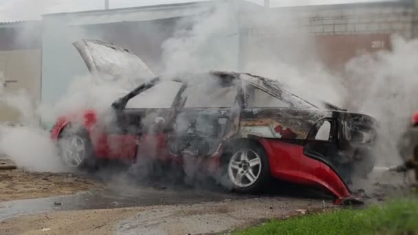 Firefighters or firemen extinguish a burnt car, automobile was not insured — Stock Video