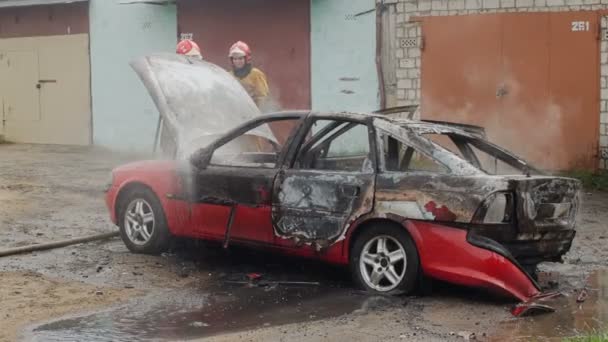 BOBRUISK, BELARUS - 25 DE JULIO DE 2018: bomberos o bomberos apagan automóvil quemado tras acto de terrorismo — Vídeos de Stock