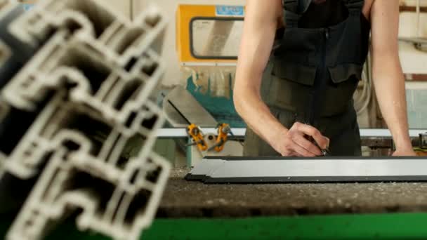 Виробництво і виробництво вікон ПВХ, робочий відзначає розмір пластиковим маркером профілю ПВХ — стокове відео