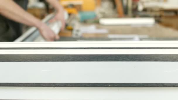 Productie en fabricage van pvc ramen, mannelijke werknemer is het maken van afgewerkte onderdelen van pvc profiel voor venster productie, pvc frame detail — Stockvideo