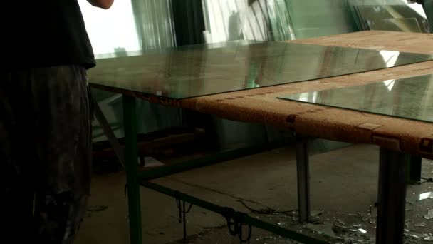 Oficina para a produção de vidro isolante, o trabalhador corta vidro com cortador de vidro para posterior montagem da unidade de vidro isolante, corte de vidro — Vídeo de Stock