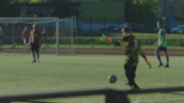 Doelman gooit in een voetbal door been, wazig voor achtergrond — Stockvideo