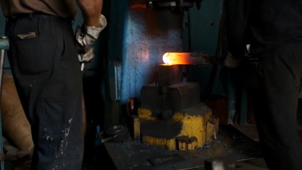 The smith in the forge forges a metal hot piece with the help of a jackhammer, pieces of scale, slow-mo — Stock Video