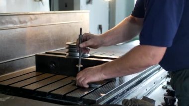 Erkek uzmanı matkap bir oyma makinesi, küçük işletme, yakın çekim üzerinde metal bir makara giderir