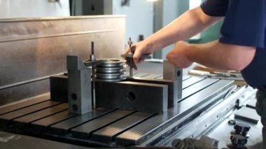 Erkek uzmanı matkap bir oyma makinesi, küçük işletme, blok üzerinde metal bir makara giderir