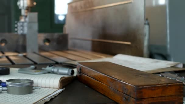 Bir matkap kasnak ölçme tablo yalan üzerinde bir delik matkap arka planda metal parçalar ile çalışmak için özel bir atölye aletleri, fabrikada — Stok video