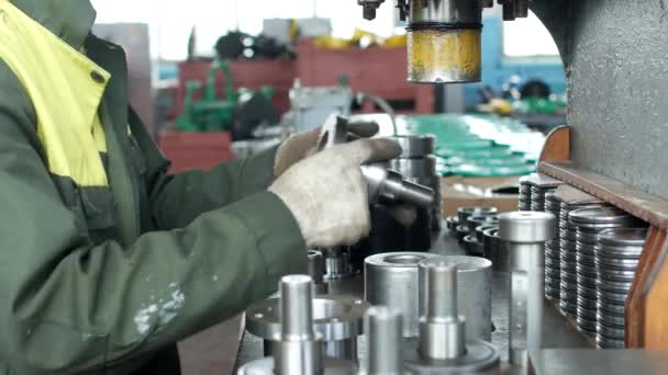 O trabalhador da fábrica pressiona o rolamento no cubo usando uma máquina de prensagem, montando o cubo, montando a unidade para engenharia mecânica, close-up, instalação — Vídeo de Stock