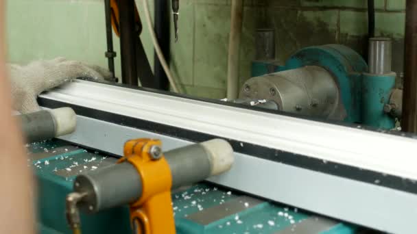 Producción y fabricación de ventanas de pvc, una trabajadora instala un perfil de pvc en la máquina y perfora un agujero debajo del mango, primer plano, fabricación de taladros — Vídeos de Stock