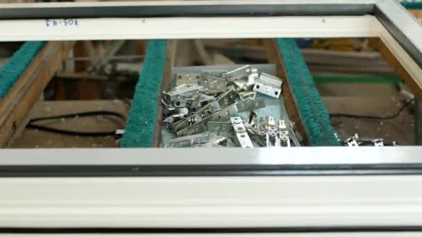 Produção de janelas de pvc, sobre a mesa estão parafusos e cortinas para janelas de PVC e chave de fenda, fabricação de quadros e janelas a partir de perfis de plástico, close-up — Vídeo de Stock