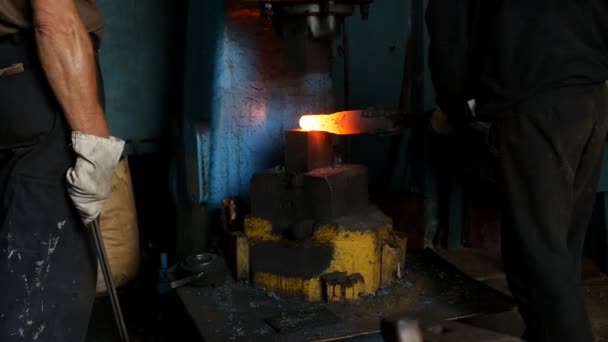De smid in de Smidse smeedt een metalen warme stuk met de hulp van een jackhammer, stukken van schaal, slow-motion — Stockvideo