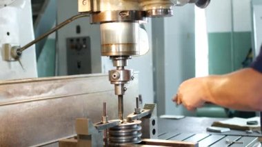 Adam uzman bir metal makara sondaj boyutu ölçüm aracıyla denetler ve bir Matkap delme makinesi, özel atölye ekler