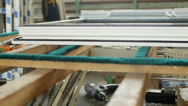 Production and manufacturing of plastic windows pvc, on the table lies the sash window, screwdriver, the shop is finished products windows — Stock Video