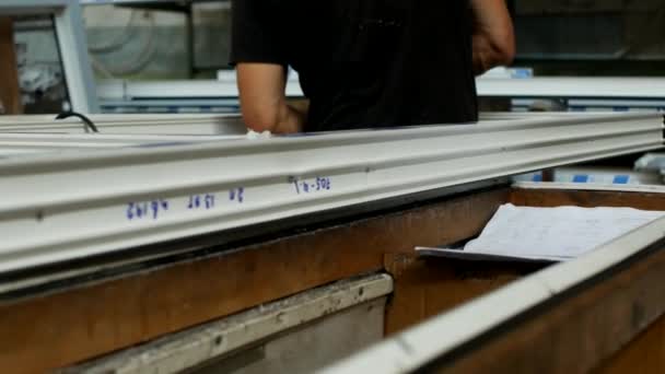 Fabricação e fabricação de janelas de PVC, um trabalhador masculino instala um selo de borracha em uma moldura de PVC, monta uma janela de PVC, montagem — Vídeo de Stock