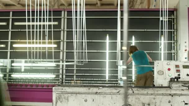 Die Werkstatt für die Herstellung von doppelt verglasten Fenstern und PVC-Fenstern, der Arbeiter holt ein doppelt verglastes Fenster aus den Fenstern, für die weitere Montage des PVC-Fensters — Stockvideo