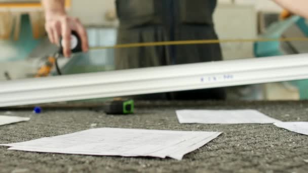 Produzione e produzione di finestre in pvc, un operaio sta misurando un pezzo di profilo in pvc e marcatura con un marcatore, nastro adesivo — Video Stock