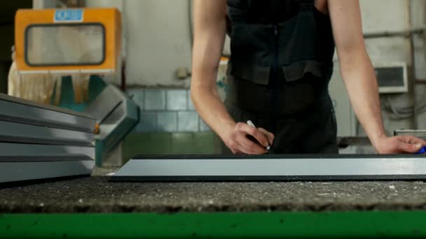 Productie en fabricage van pvc ramen, de werknemer markeert de grootte met een kunststof pvc profiel marker — Stockvideo