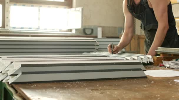 Production of PVC windows from the profile, the male worker marks the dimensions on the pvc profile, for further assembly of the PVC window, manufacturing — Stock Footage Production of PVC windows from the profile, the male worker marks the dimensions on the pvc profile, for further assembly of the PVC window, manufacturing Royalty Free Stock Footage