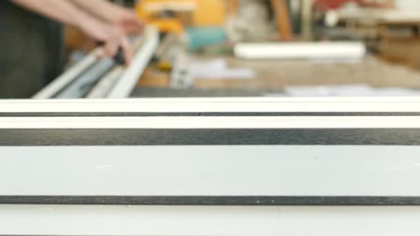 Production and manufacturing of pvc windows, a male worker is measuring a pvc profile piece and marking with a marker, tape-measure and marker, tape-measure — Stock Footage Production and manufacturing of pvc windows, a male worker is measuring a pvc profile piece and marking with a marker, tape-measure and marker, tape-measure Stock Video