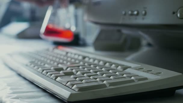 Cientista ou pesquisador médico insere dados no teclado em um computador — Vídeo de Stock